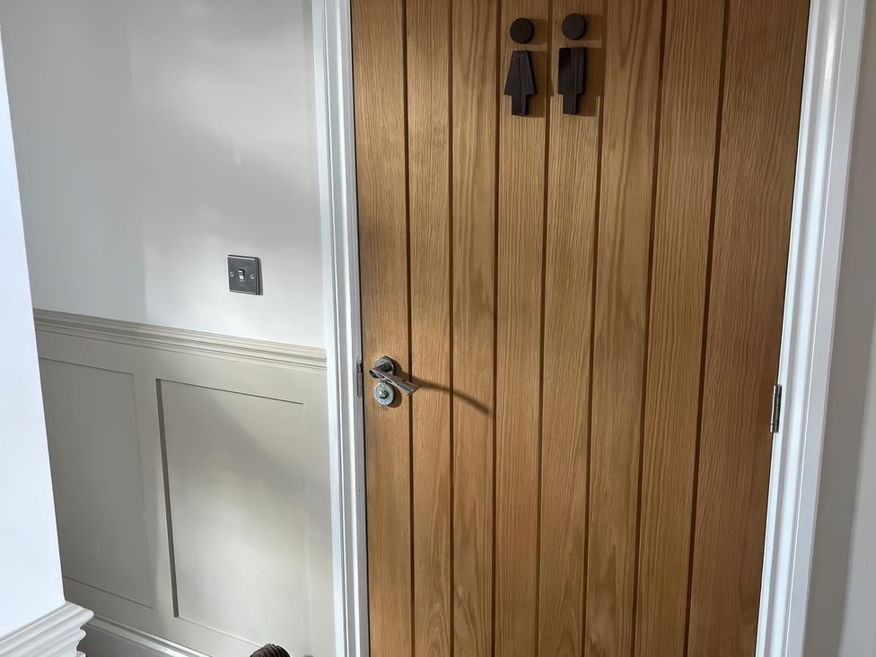 A door with toilet signs at Craster House in Seahouses