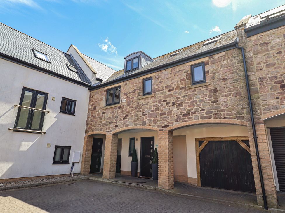 An exterior view of a property with multiple windows and a door at Craster House in Seahouses