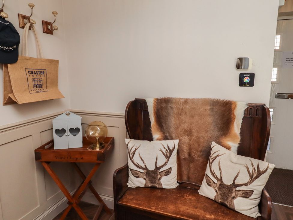 An entrance with a bench and decorative items at Craster House in Seahouses