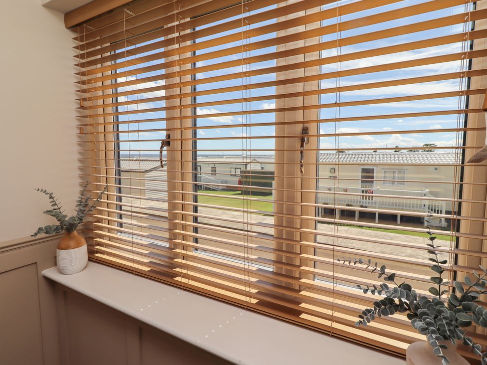 A window with blinds and plants on the sill at Craster House in Seahouses