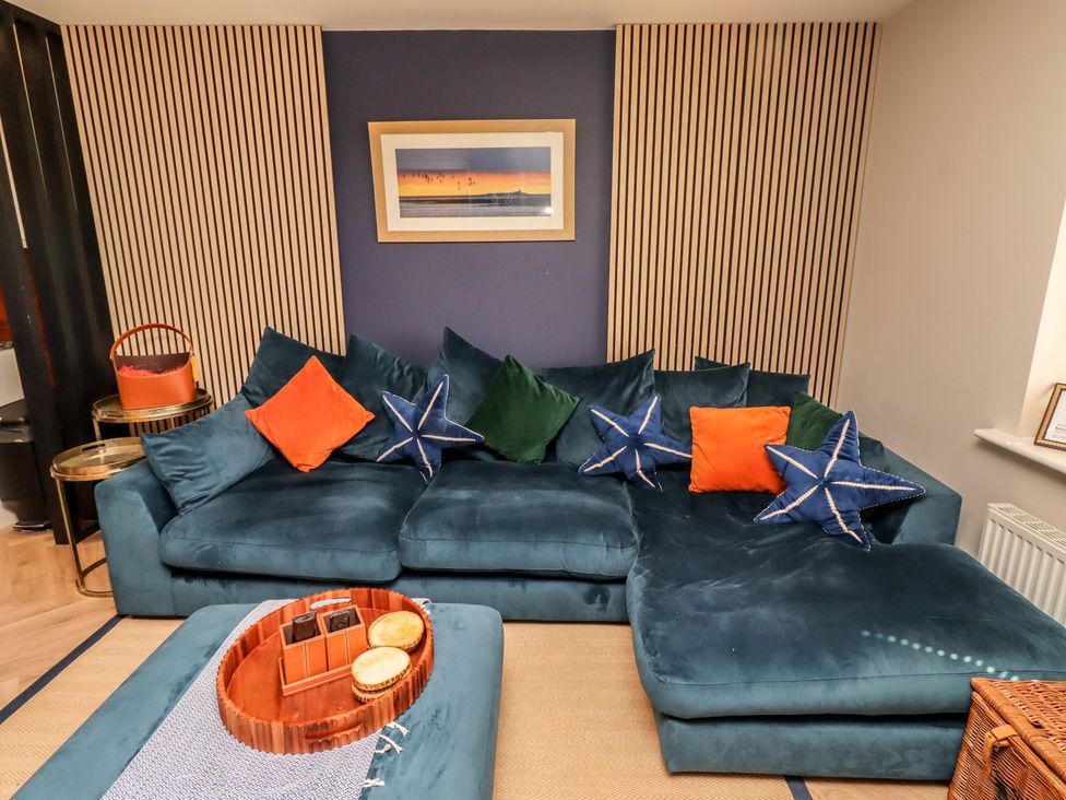 A living room with a sofa and coffee table at Craster House in Seahouses