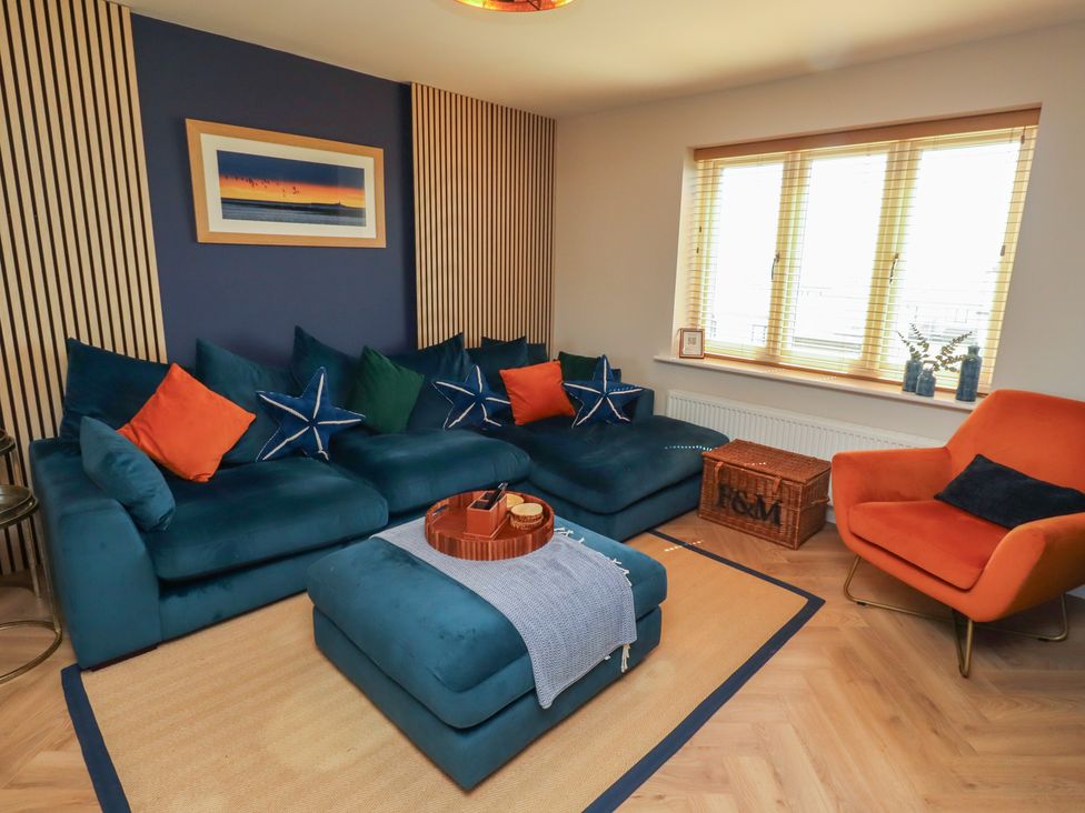 A living room with a sofa and an armchair at Craster House in Seahouses