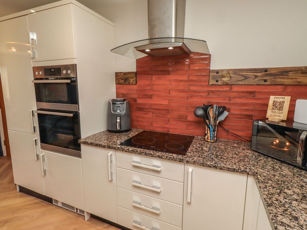 A kitchen with modern appliances and utensils at Craster House in Seahouses