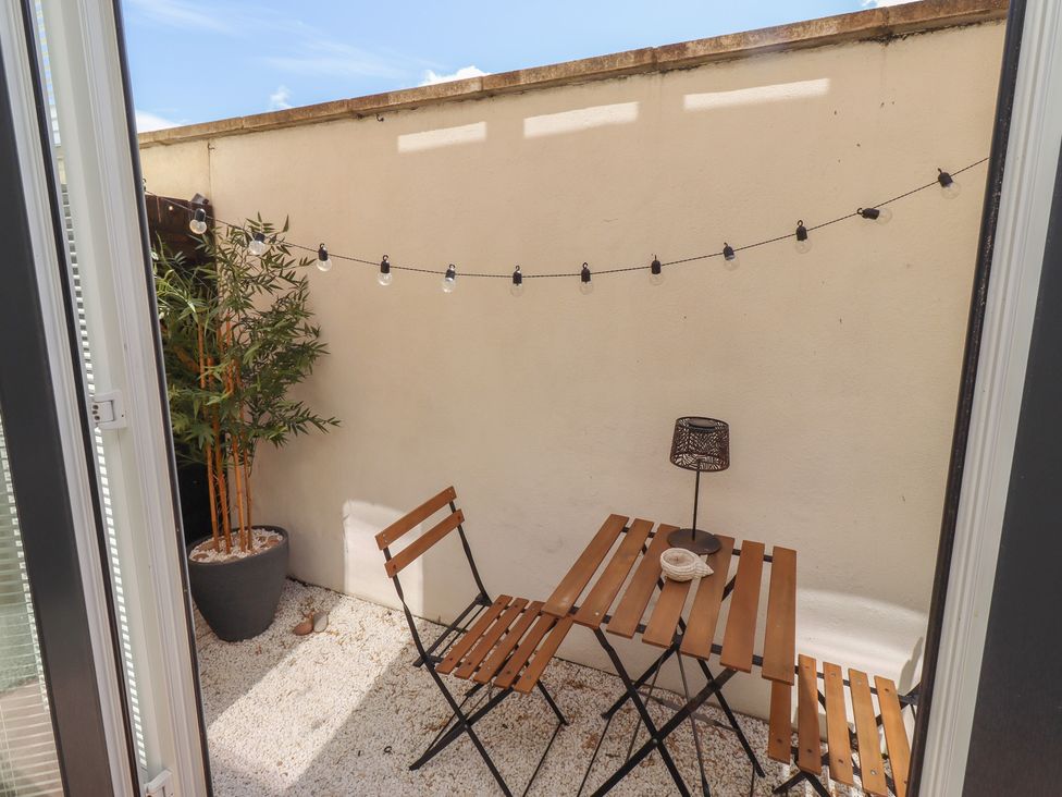 An outdoor terrace with a table and chairs at Craster House in Seahouses