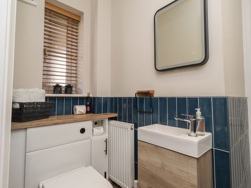 A bathroom with a sink and mirror at Craster House in Seahouses