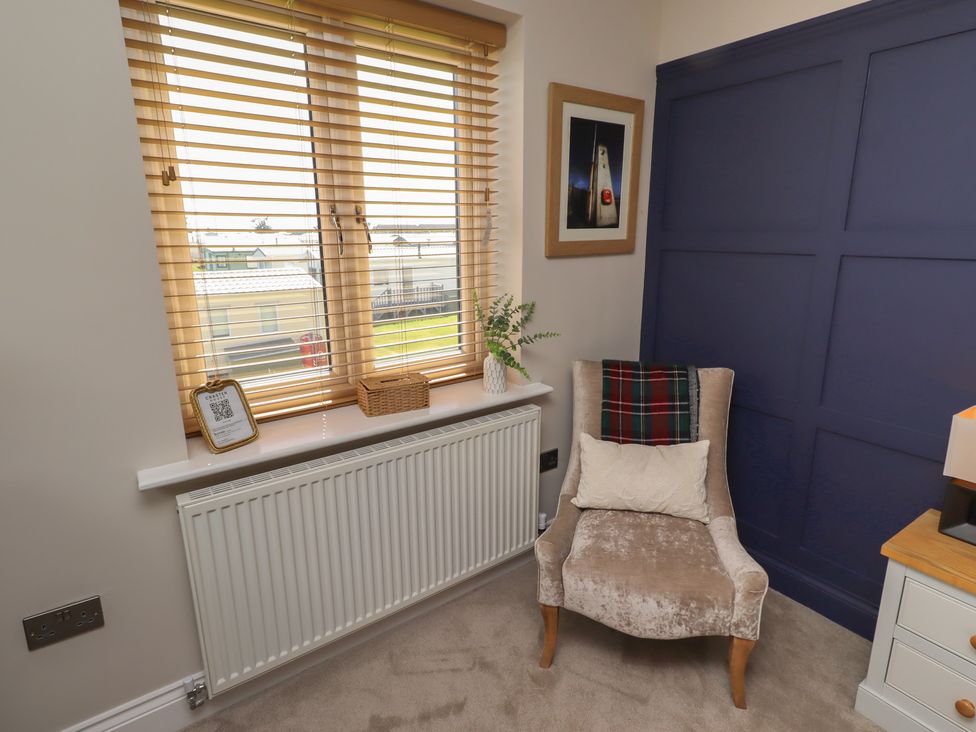 A sitting room with a chair and a table at Craster House in Seahouses