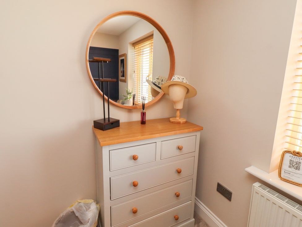 A dresser with a mirror and a hat at Craster House in Seahouses