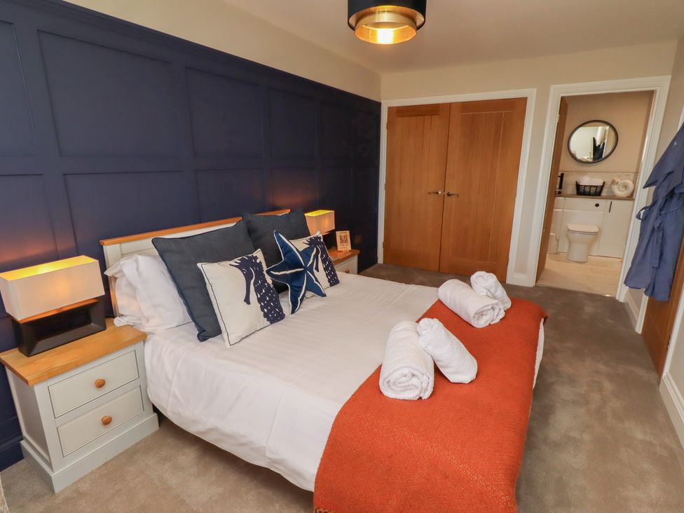 A bedroom with a bed and nightstands at Craster House in Seahouses