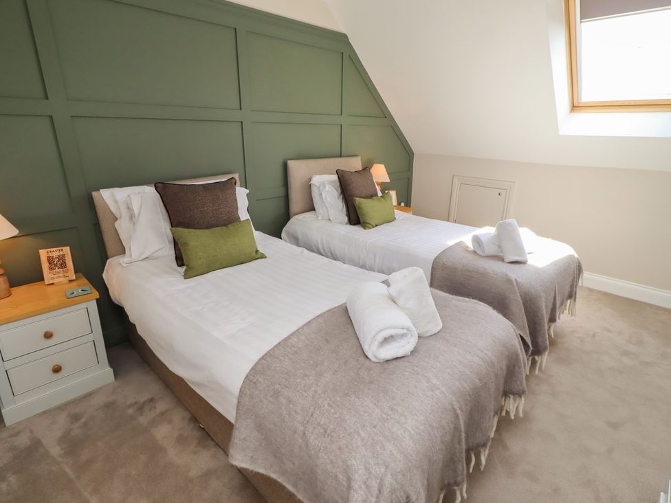 A bedroom with two single beds and a nightstand at Craster House in Seahouses