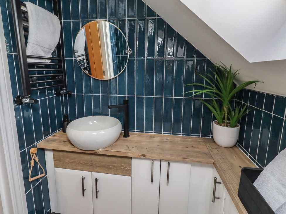 A bathroom with a sink and a mirror at Craster House in Seahouses