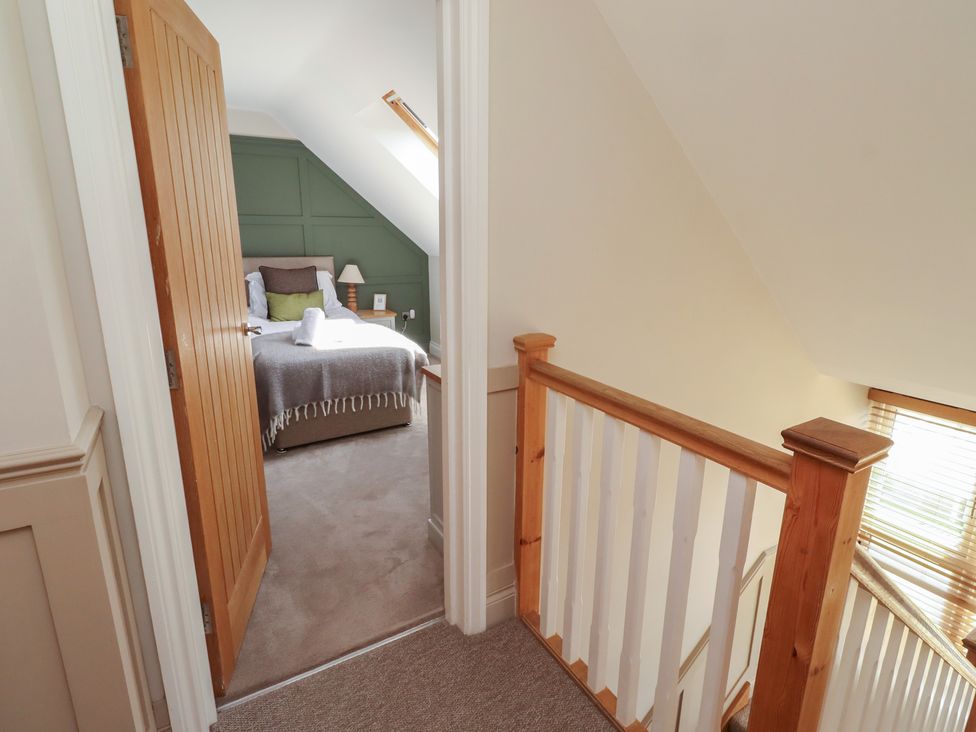 A staircase leading to a bedroom with a bed and lamp at Craster House in Seahouses