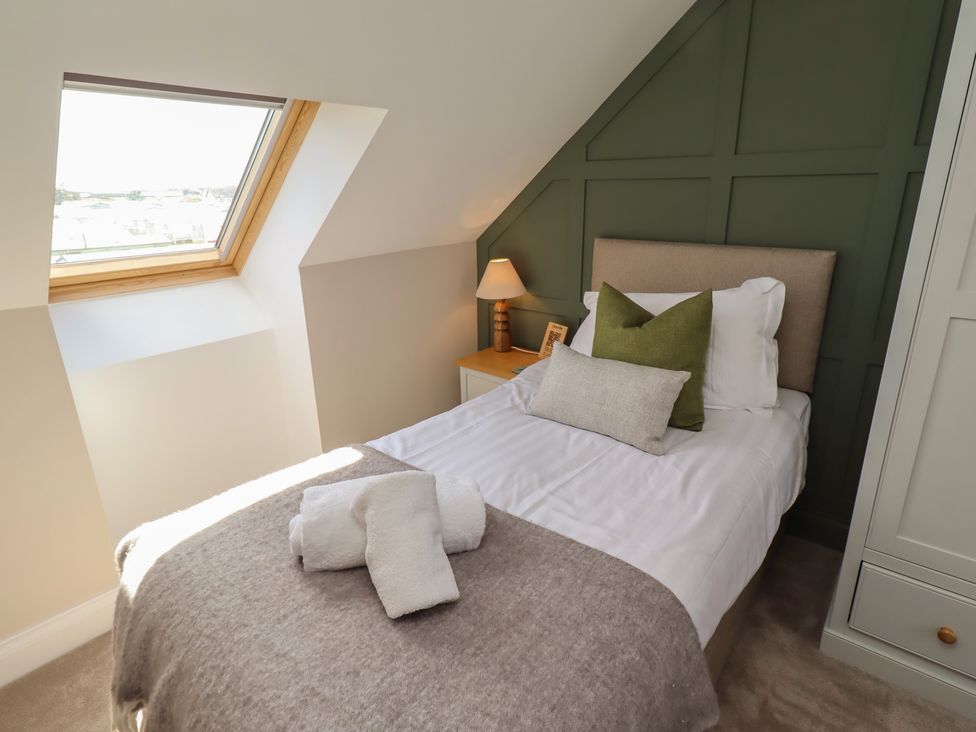 A bedroom with a single bed and window at Craster House in Seahouses