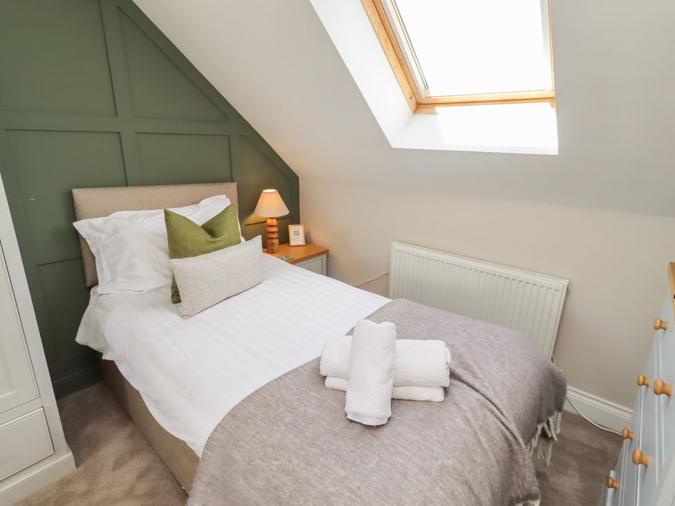 A bedroom with a bed and lamp at Craster House in Seahouses