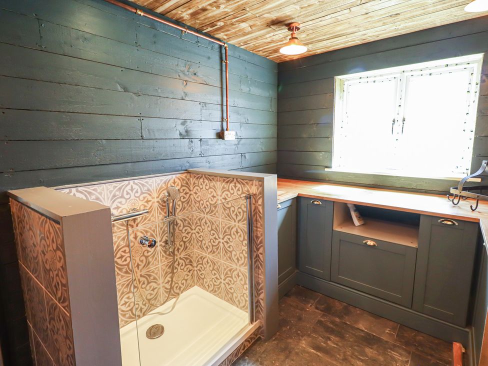 A bathroom with a shower and a cabinet at Craster House in Seahouses