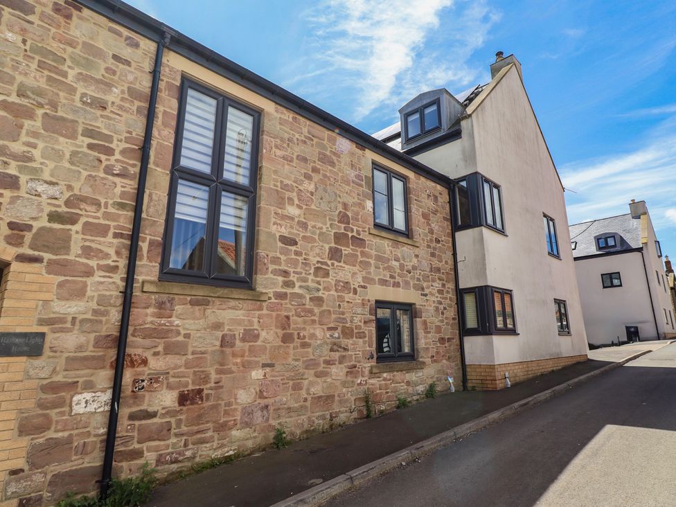 An exterior view of a stone building with windows at Craster House Seahouses