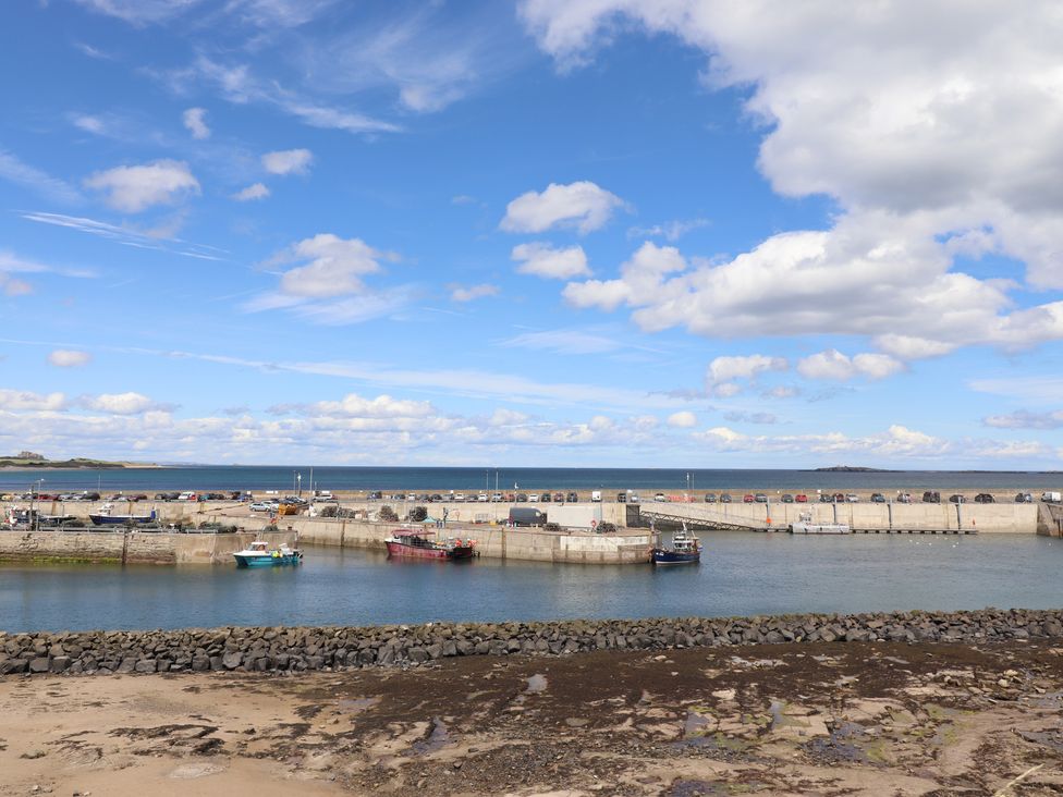 A harbor with boats and cars parked at Craster House in Seahouses