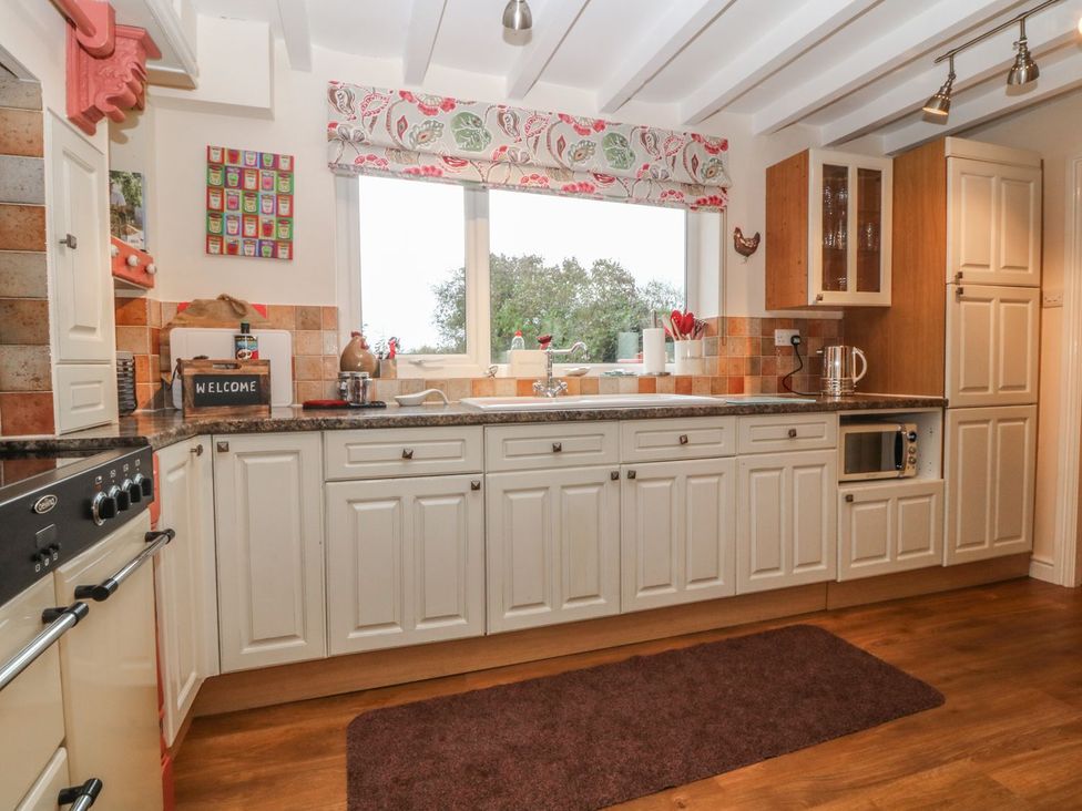 A kitchen with cabinets and a stove at Rhianfa in Llanfairpwllgwyngyll