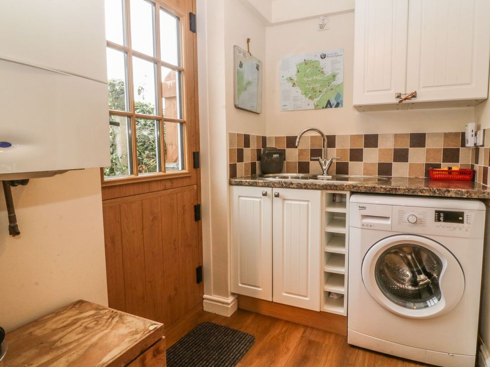 A laundry room with a washing machine and sink at Rhianfa in Llanfairpwllgwyngyll