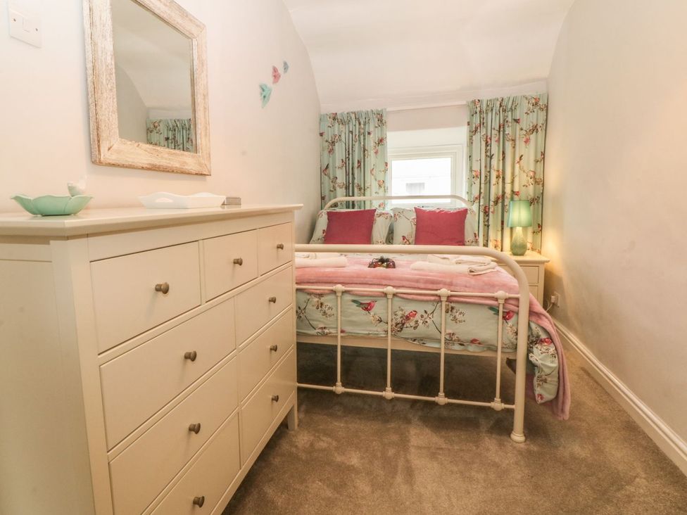 A bedroom with a bed and dresser at Rhianfa in Llanfairpwllgwyngyll
