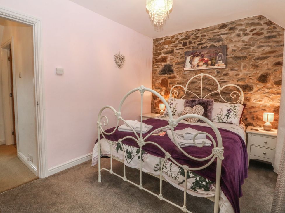 A bedroom with a bed and nightstands at Rhianfa in Llanfairpwllgwyngyll