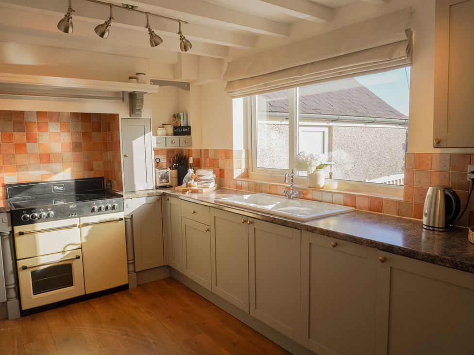 A kitchen with a stove and sink at Rhianfa Newborough