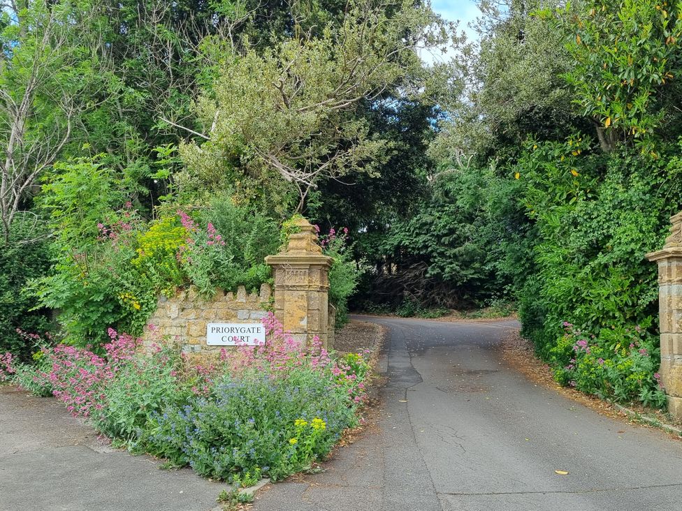 A view of a sign and flowerbed at the entrance to Priorygate Court