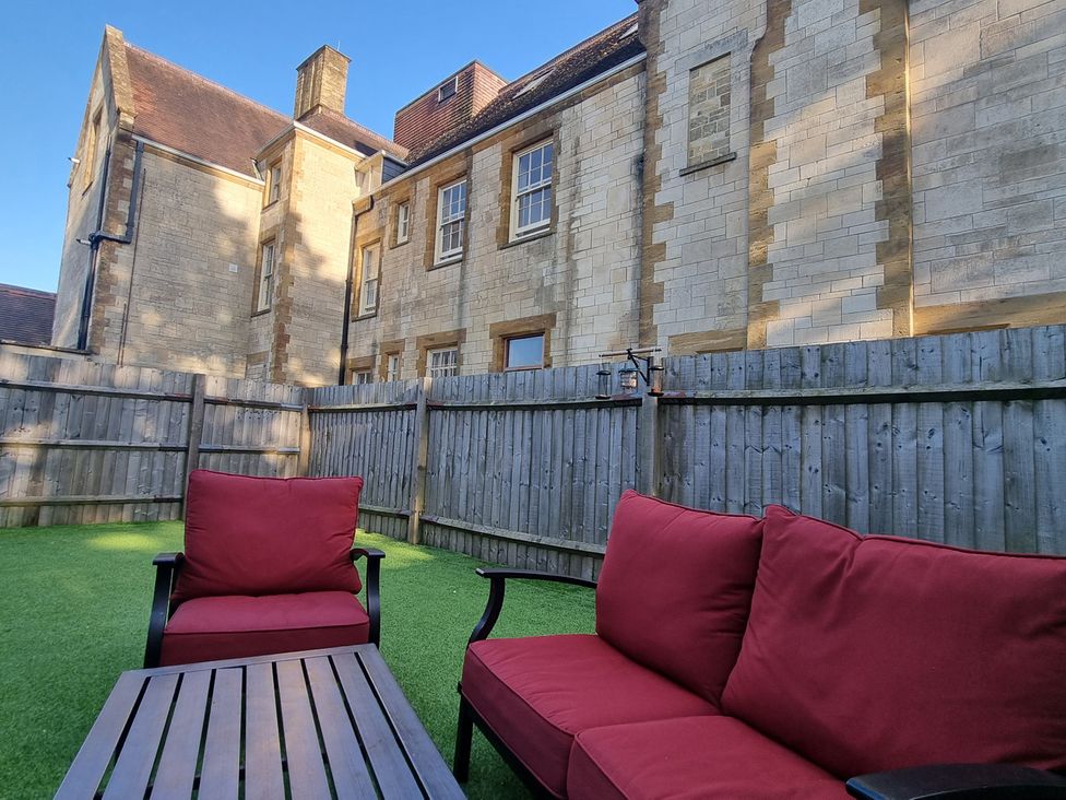 A garden with a sofa and table at The Coach House in Castle Cary