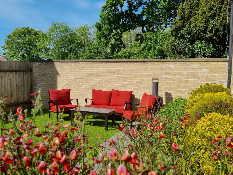 A garden with seating and flowers at The Coach House in Castle Cary