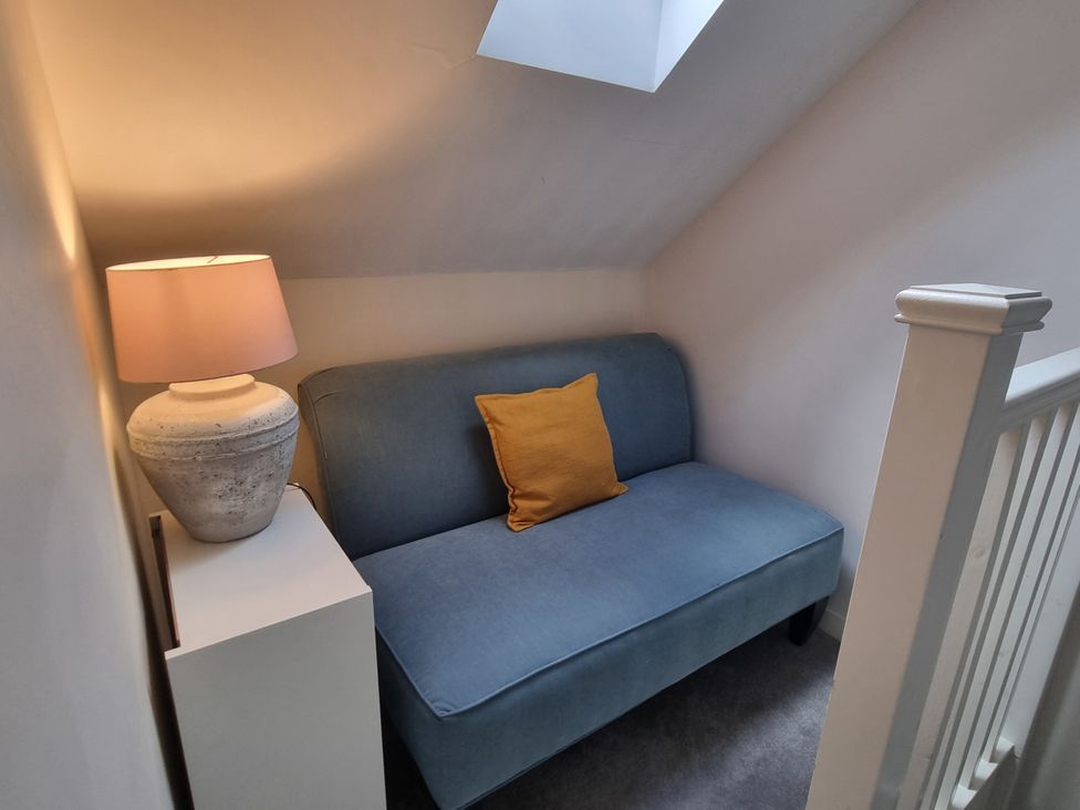 A landing area with a sofa and lamp at The Coach House in Castle Cary
