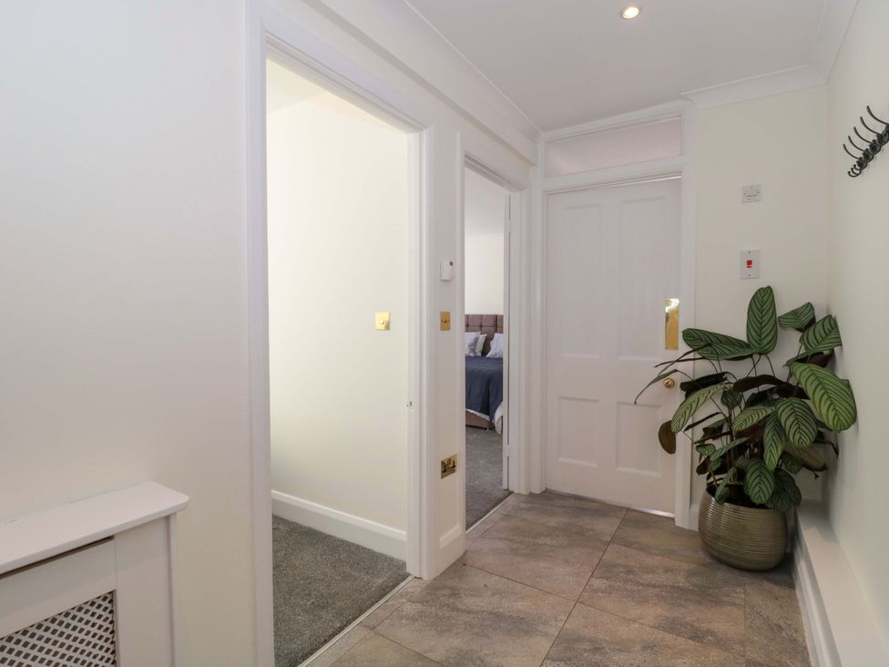 A hallway with a plant and doors at Flat 2 Battledown Grange, Cheltenham
