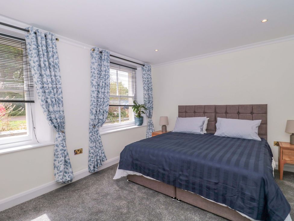 A bedroom with a bed and curtains at Flat 2 Battledown Grange, Cheltenham