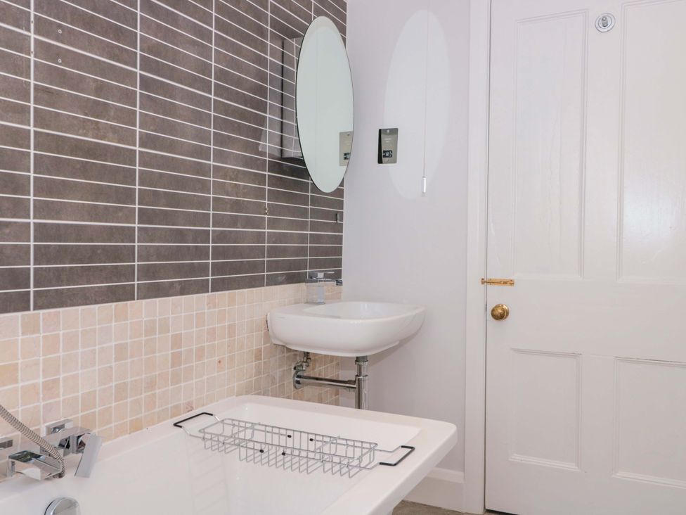 A bathroom with a bathtub and a sink at Flat 2 Battledown Grange Cheltenham