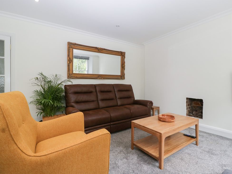 A living room with sofa, armchair, coffee table and mirror at Flat 2 Battledown Grange Cheltenham