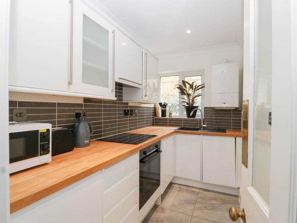 A kitchen featuring a sink, oven, and cabinets at Flat 2 Battledown Grange, Cheltenham