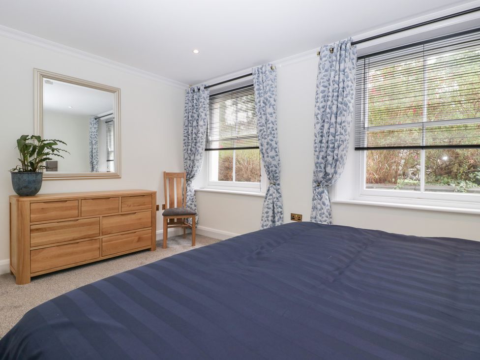 A bedroom with a bed and dressing table at Flat 2 Battledown Grange in Cheltenham