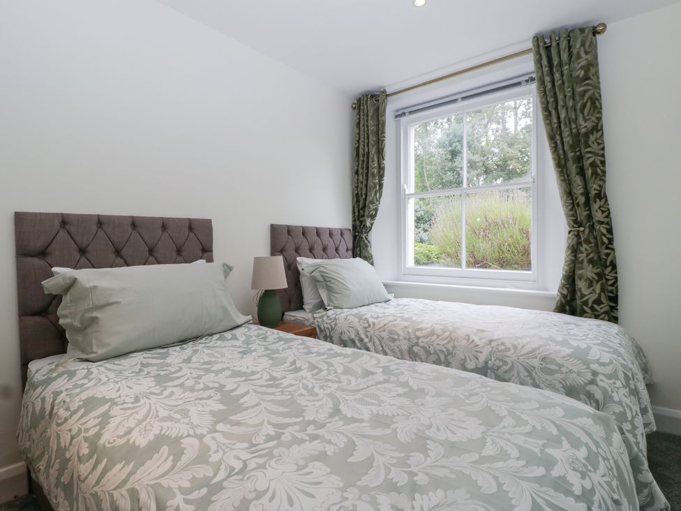 A bedroom with two single beds and a window at Flat 2 Battledown Grange in Cheltenham