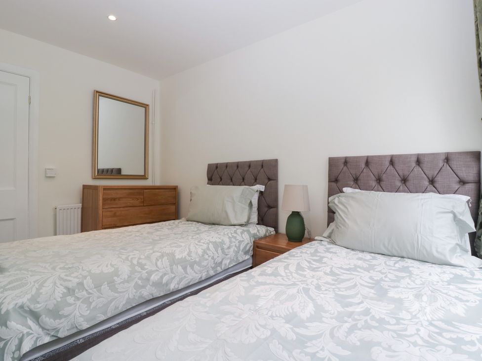 A bedroom with two single beds and a mirror at Flat 2 Battledown Grange Cheltenham