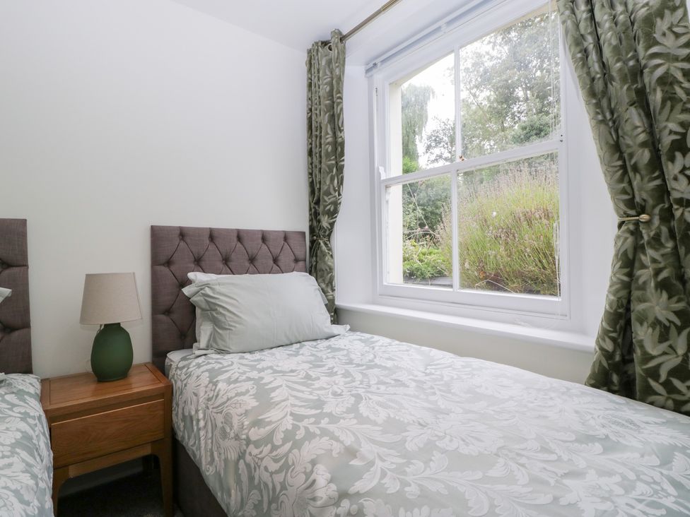 A bedroom with two beds and a window at Flat 2 Battledown Grange in Cheltenham