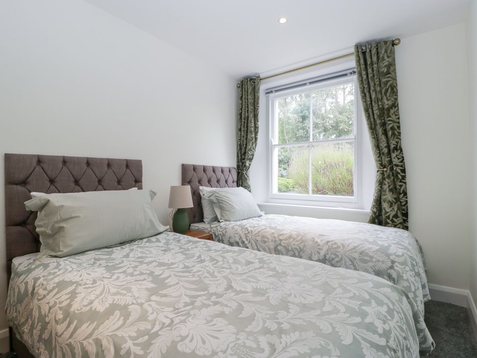 A bedroom with two beds and a window at Flat 2 Battledown Grange in Cheltenham