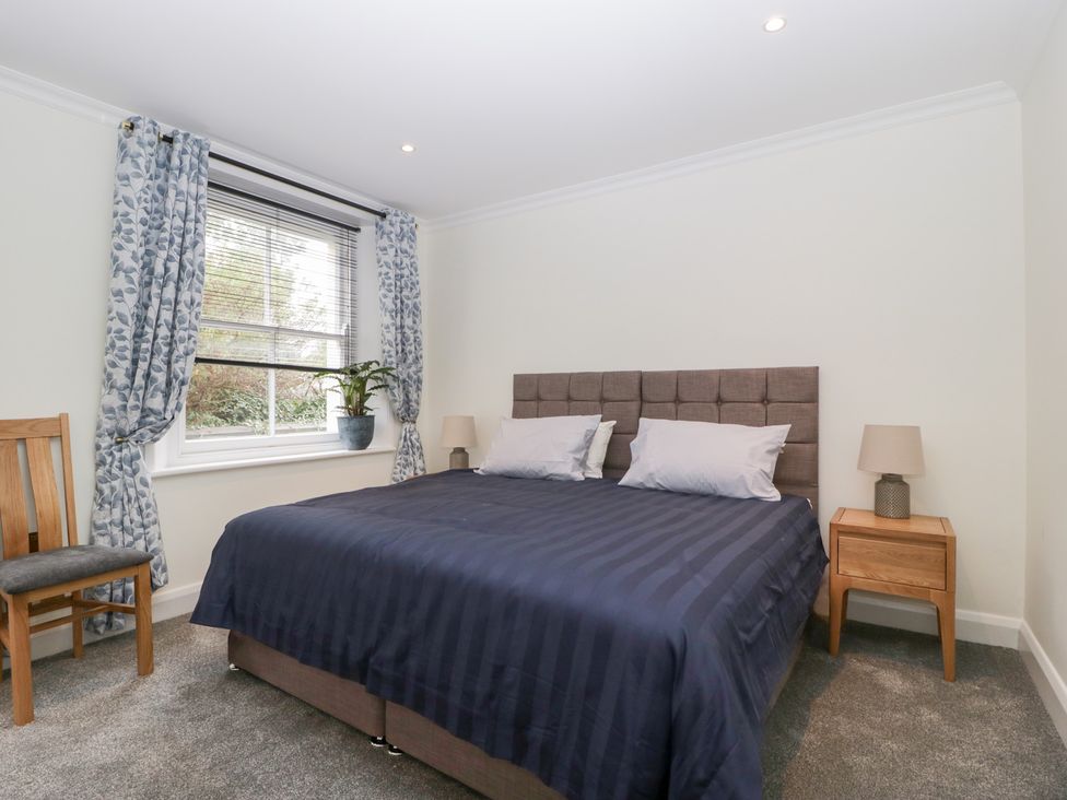 A bedroom with a bed and a bedside table at Flat 2 Battledown Grange in Cheltenham
