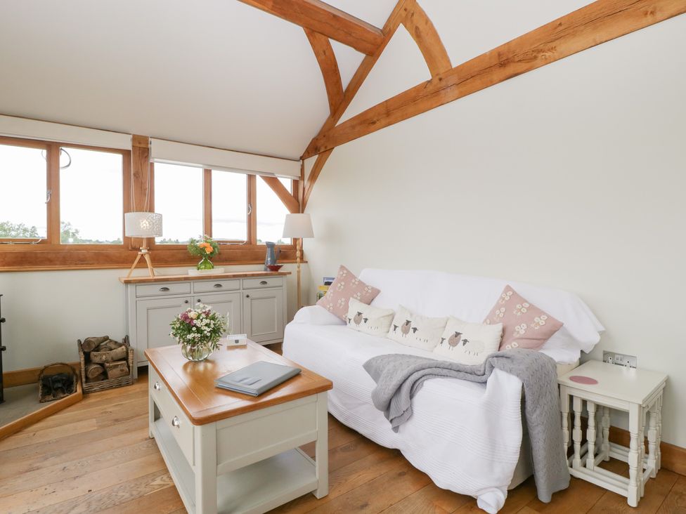 A living room with a sofa and coffee table at Little Acorn Cottage in Munsley near Ledbury