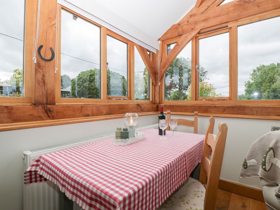 A dining room with a table set for two at Little Acorn Cottage in Munsley near Ledbury
