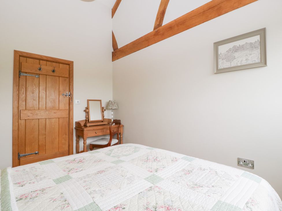 A bedroom with a bed and a table at Little Acorn Cottage in Munsley near Ledbury