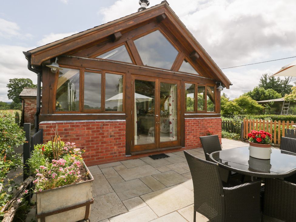 A garden with a patio table and chairs at Little Acorn Cottage Munsley near Ledbury