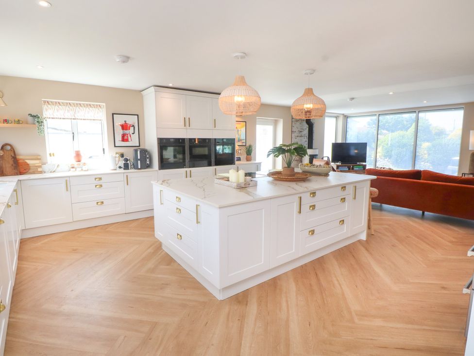 A kitchen with an island and modern appliances at Ardwyn Rhosneigr