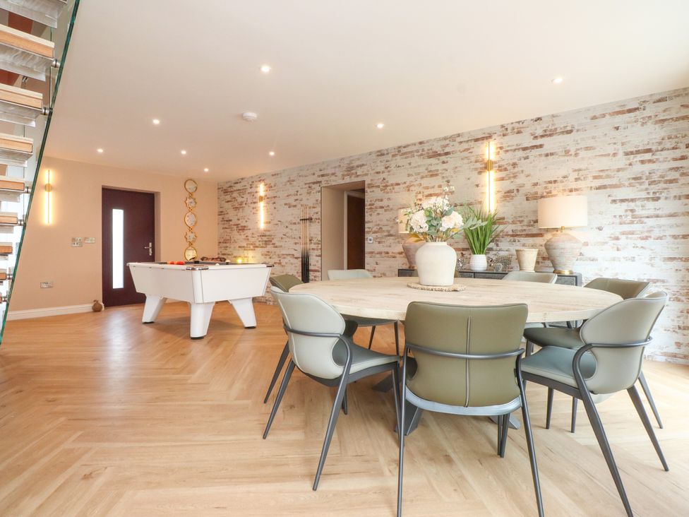 A dining room with a table and chairs and a pool table at Ardwyn Rhosneigr
