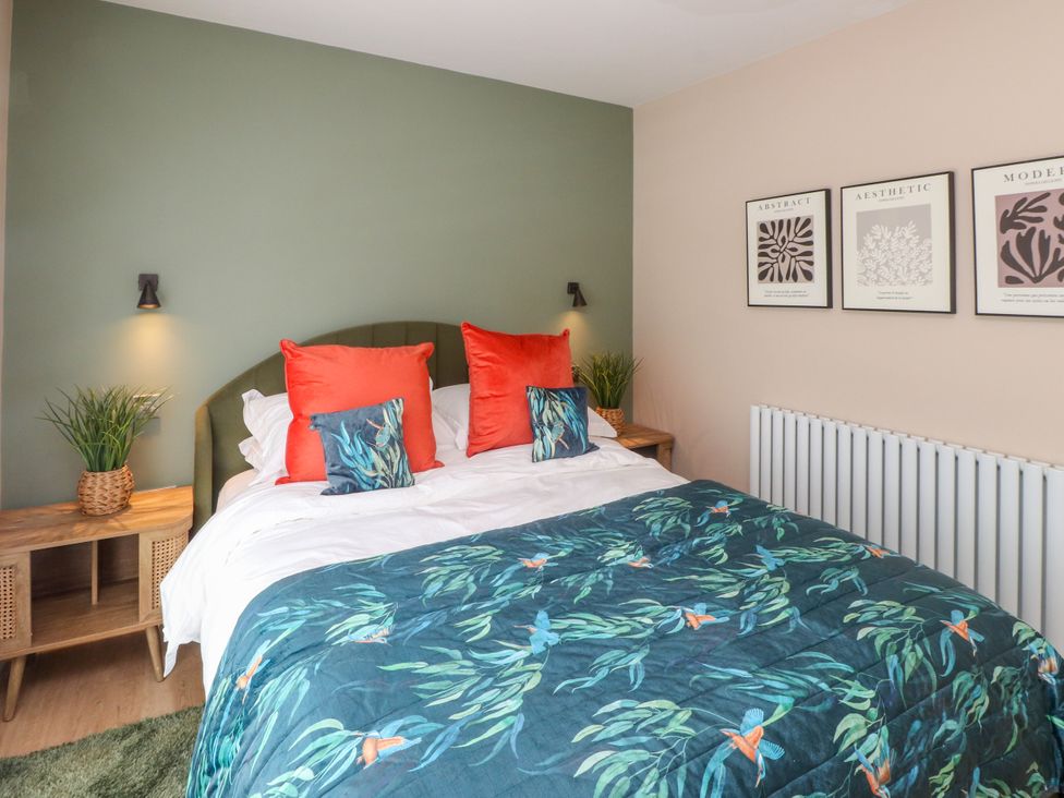 A bedroom with a bed and wall art at Ardwyn in Rhosneigr