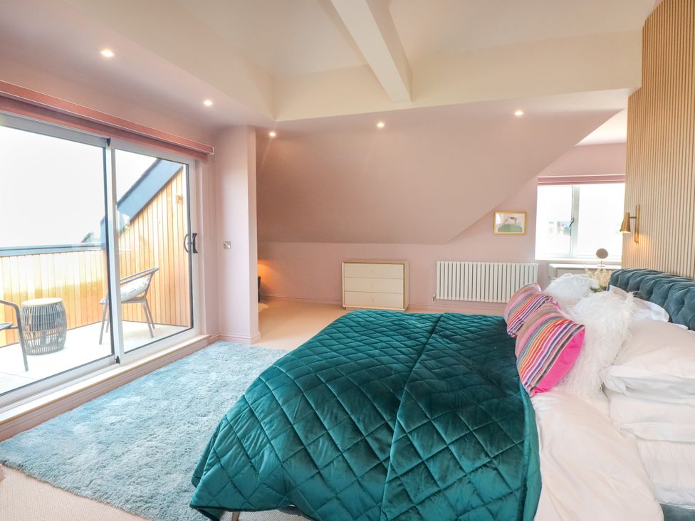 A bedroom with a bed and dresser at Ardwyn in Rhosneigr