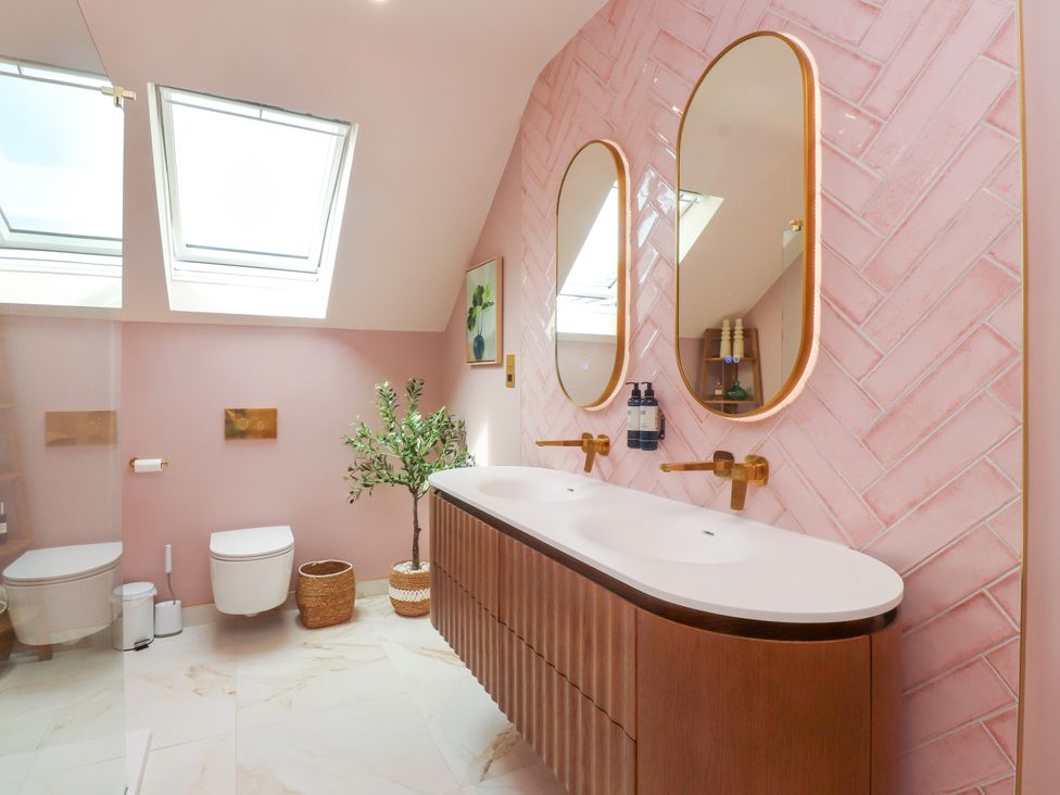 A bathroom with a washbasin and mirrors at Ardwyn in Rhosneigr