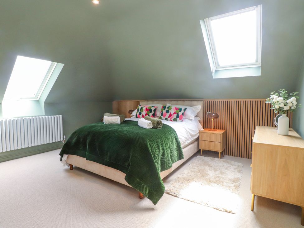 A bedroom with a bed and decorative pillows at Ardwyn Rhosneigr